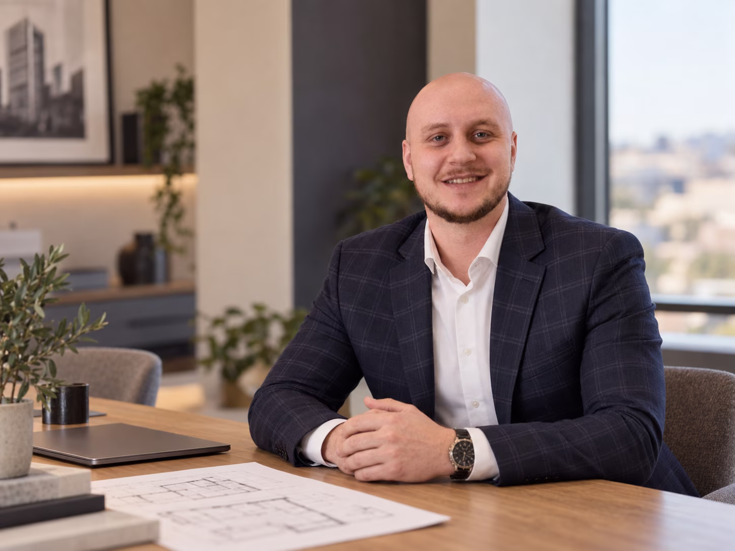 Bartłomiej Drelich przy stole z planami nieruchomości